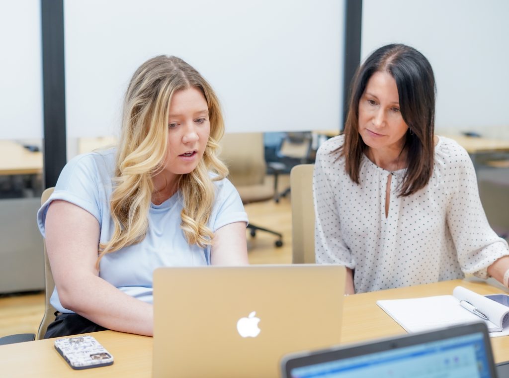 Ashley and Nicole from Risch Results looking at laptop